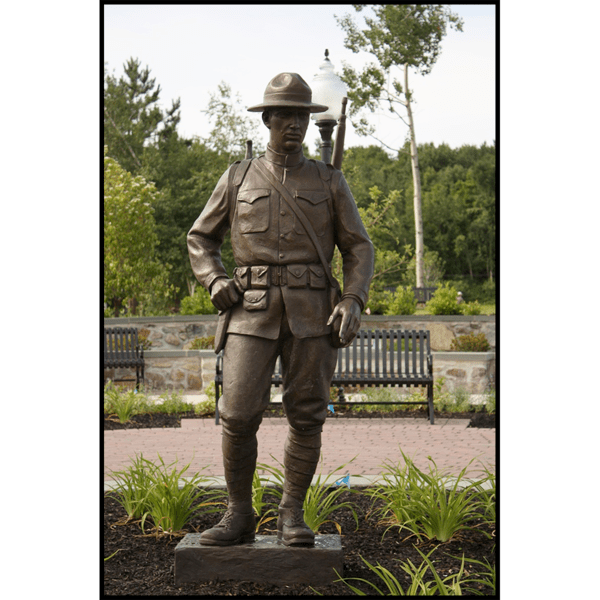 photo of bronze-colored sculpture of soldier in park setting