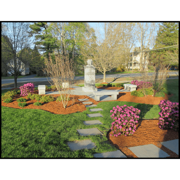 photo of granite memorial surrounded by hardscaping, landscaping, and granite benches