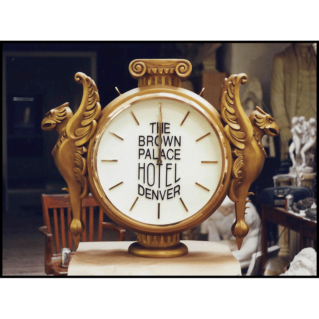 photo of gold clock with white face and griffins in profile on either side