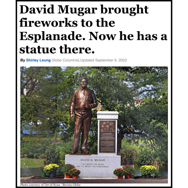 image of news article title and photo featuring statue of man standing on granite base surrounded by landscaping with river behind