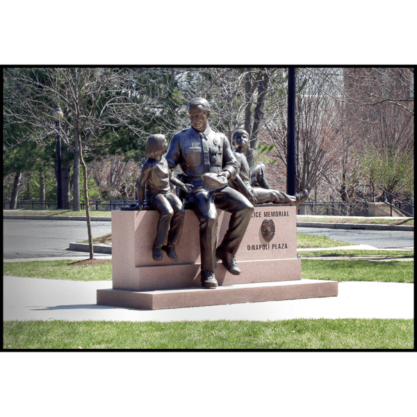 photo of bronze sculpture of adult with two children on stone bench