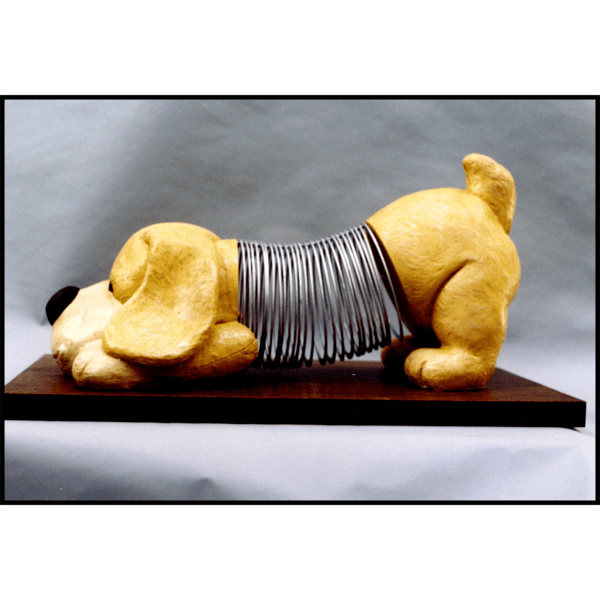 photo of sculpture of dog and slinky toy with polychrome finish on gray background