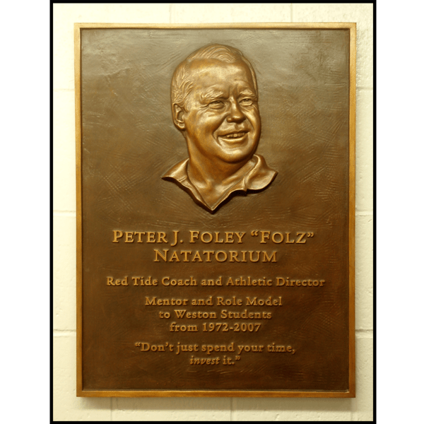 photo of bronze plaque with relief sculpture of Peter Foley on tiled wall