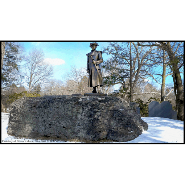 photo of bronze statue of Joseph Warren in uniform holding sword hilt at his side atop a large puddingstone