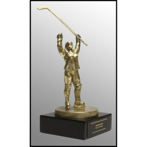 photo of gold-colored sculpture of female hockey player in gear raising her stick in the air and other arm raised atop a black stone base with plaque