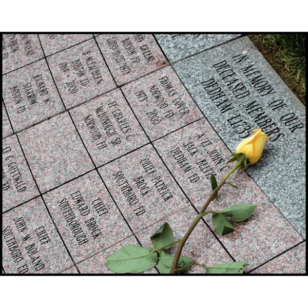 photo of brick and stone pavers with inscriptions and yellow rose laid on top