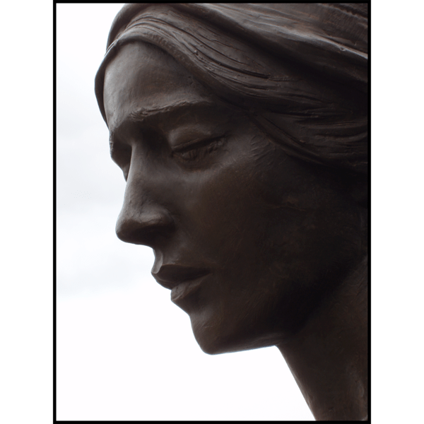 photo closeup of bronze sculpture of female figure's face