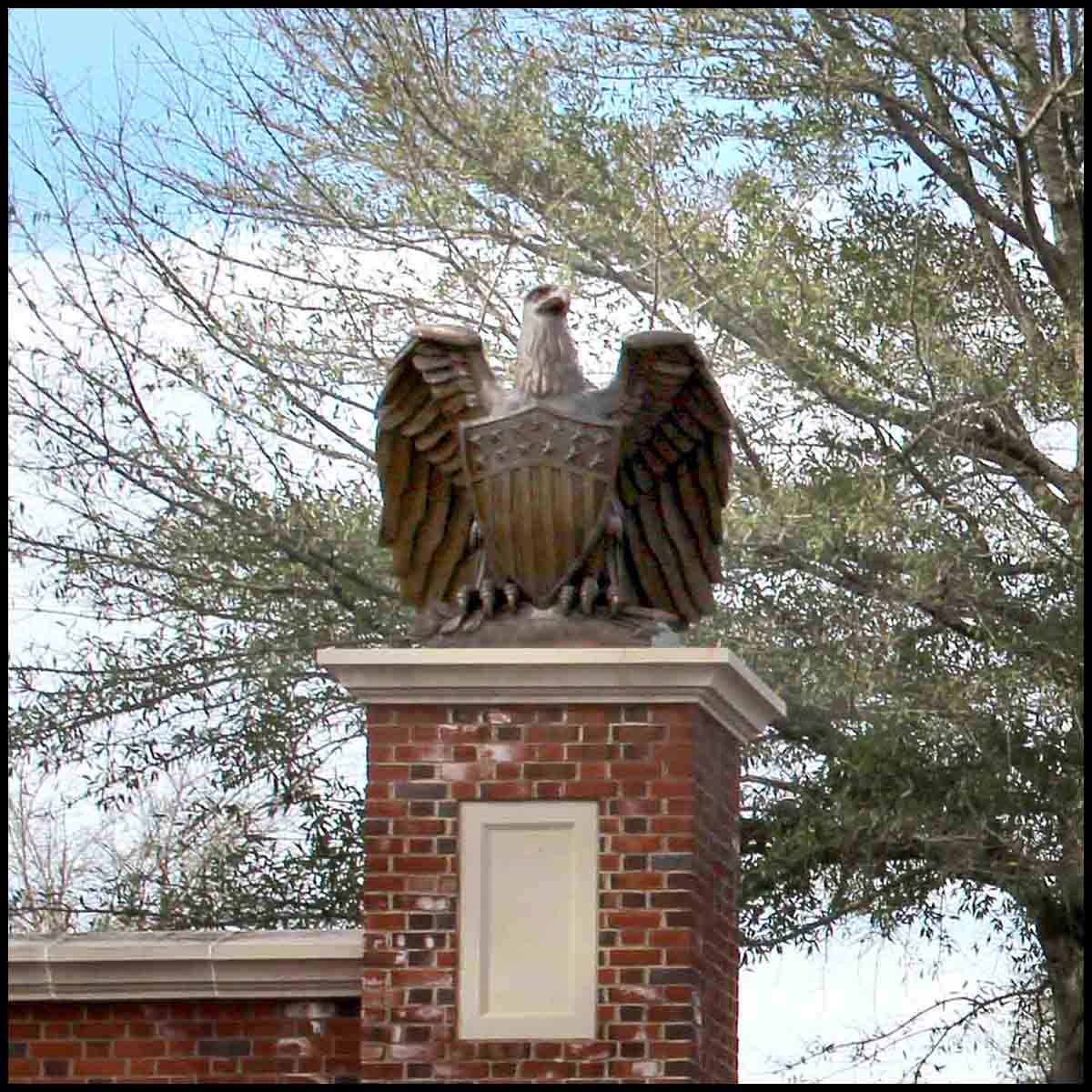 photo of bronze eagle sculpture atop brick gateway post