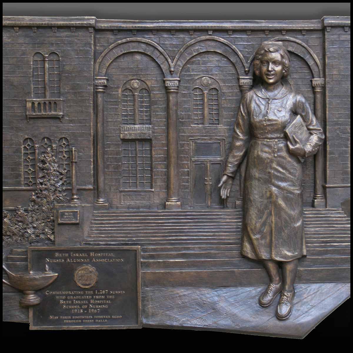 photo of bronze-colored relief plaque of female nurse walking outside hospital building