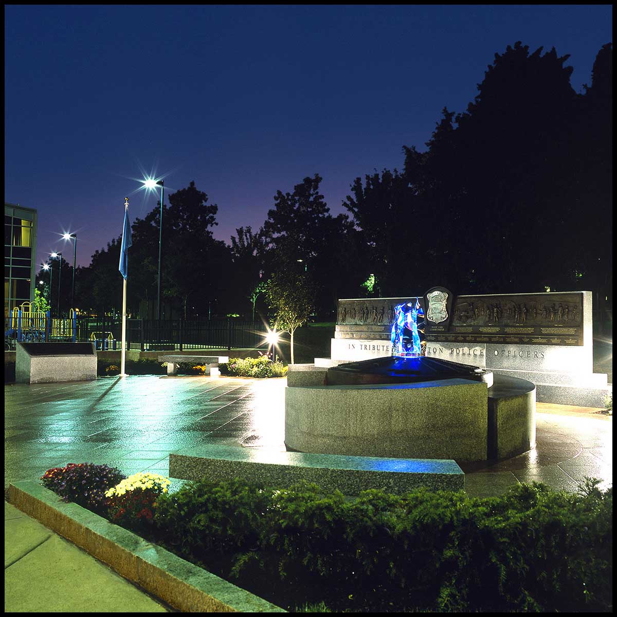 exterior photo of plaza lit at night with large granite memorials