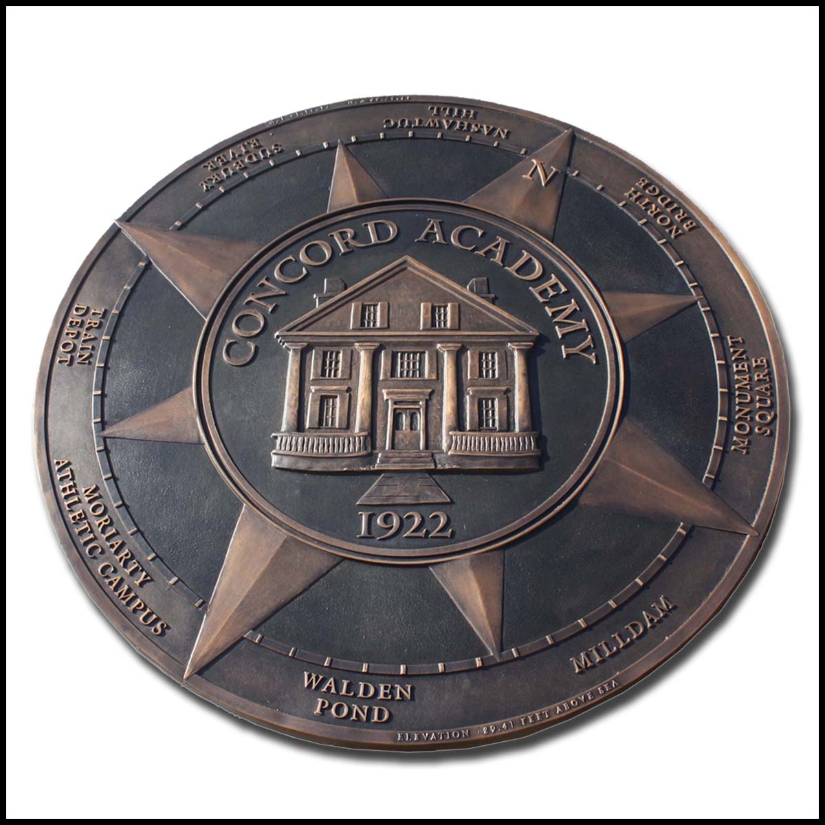 photo of bronze floor medallion with relief sculpture of building and compass elements