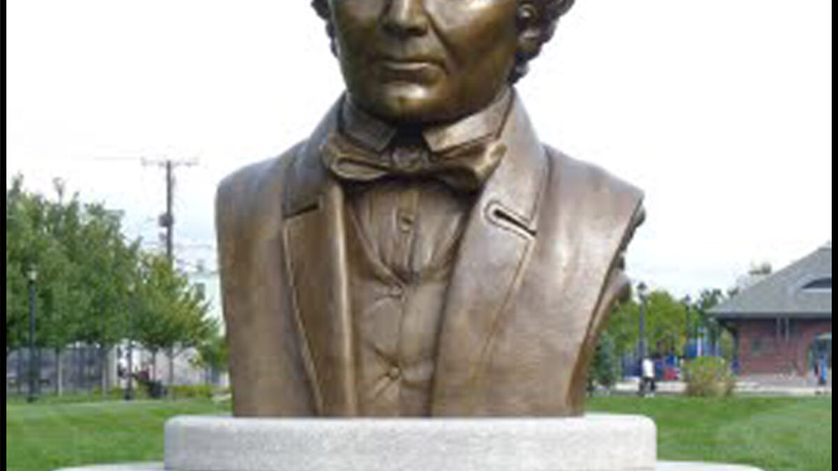 photo of monumental bronze bust of Donald McKay on stone base outdoors on grass