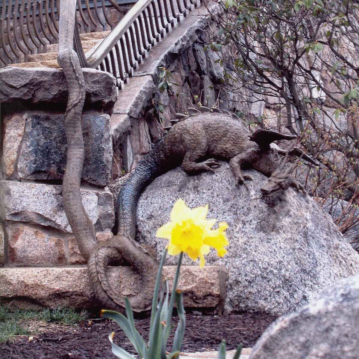 photo of building with stone staircase with a bronze dragon perched on a rock at the bottom