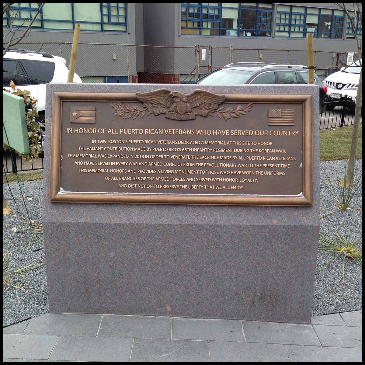 photo of bronze plaque with text and eagle in relief at the top on a granite base
