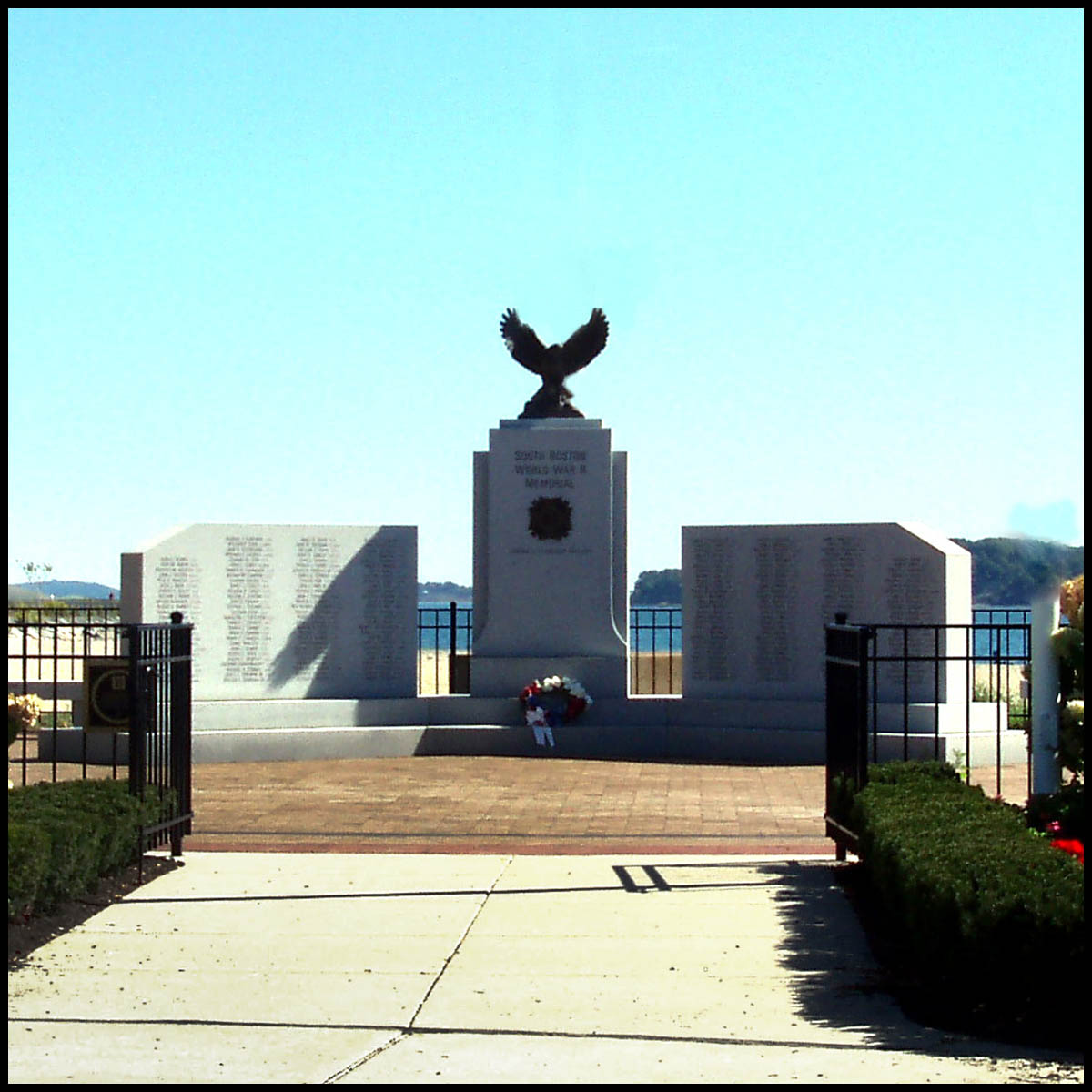 photo of granite monument with bronze eagle sculpture atop central piece in plaza