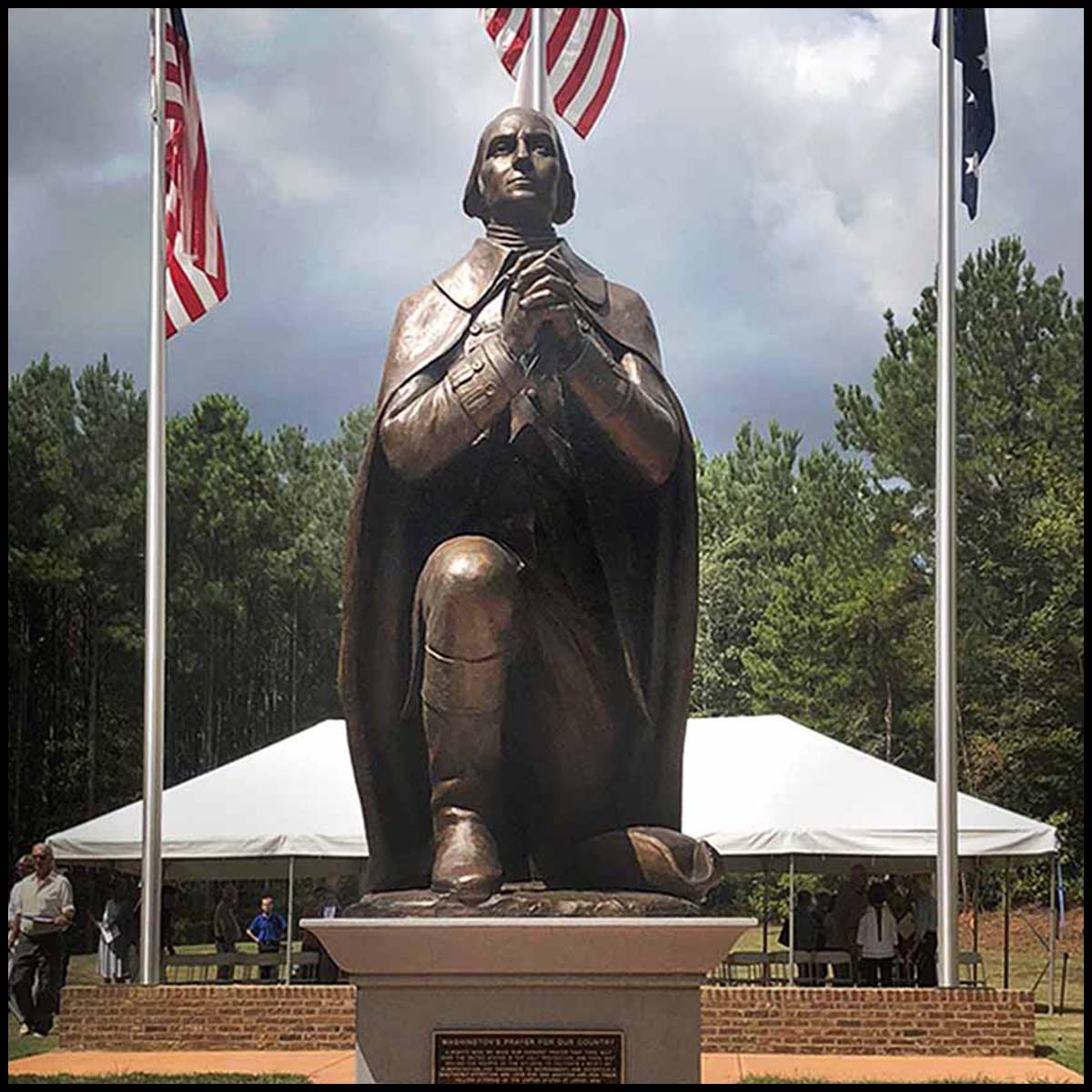 exterior photo of bronze sculpture of George Washington kneeling and praying on stone base